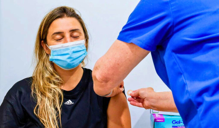 Una mujer cierra los ojos mientras recibe una vacuna contra el COVID-19 en el consultorio médico familiar de Sydney Road, en Sídney, Australia, el 10 de enero de 2022. (Jenny Evans/Getty Images) Fuente: The Epoch Times en español